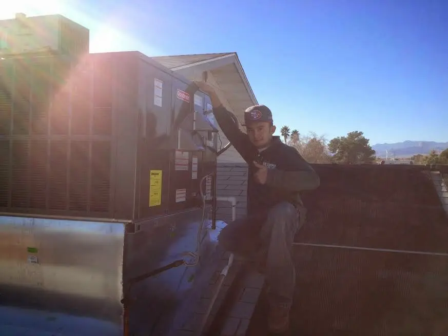 HVAC technician performing Heat Pump Repair on a rooftop unit in Spring Hill